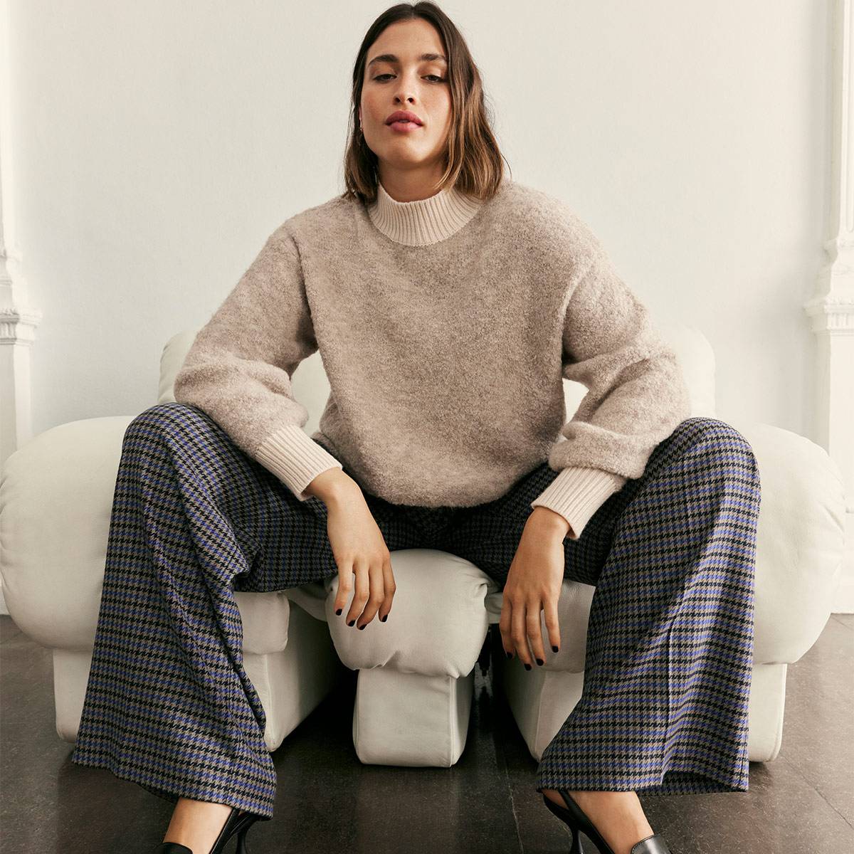 Woman wearing beige knit and checked pants